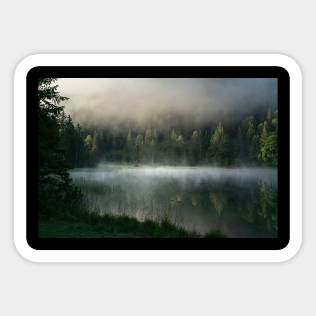 Magic Misty Lake. Amazing shot of a wooden house in the Ferchensee lake in Bavaria, Germany, in front of a mountain belonging to the Alps. Scenic foggy morning scenery at sunrise. Sticker by EviRadauscher